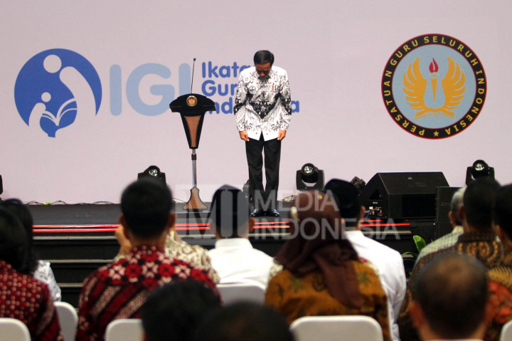 Jokowi membungkukkan badannya di hadapan ribuan guru.