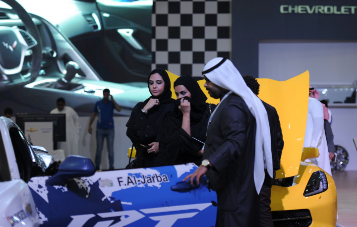 Dua orang wanita bercadar mengintip kabin mobil balap tim Chevrolet. Bilyuner Pangeran Alwaleed bin Talal (20/11) mengusulkan pencabutan segera larangan bagi wanita mengemudikan kendaraan sehingga mendorong konsumsi mobil dan bahan bakar yang demi mendongkrak pertumbuhan ekonomi Arab Saudi. AFP PHOTO / FAYEZ NURELDINE