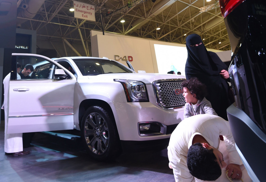 Seorang pria bersama istri dan anaknya mencermati SUV GMC Denali 4x4. Sebagai negara petro dollar, Arab Saudi masih salah satu pasar empuk untuk sportcar mewah meski pertumbuhan ekonominya sedang melambat. AFP PHOTO / FAYEZ NURELDINE