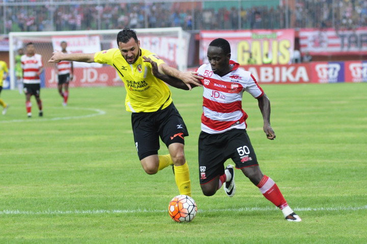 Pesepakbola Madura United FC Eric Weeks (kanan) melewati pesepakbola Semen Padang, Muamer Svraka dalam lanjutan kompetisi Torabika Soccer Championship (TSC) di Stadion Gelora Ratu Pamelingan (SGRP), Pamekasan, Jawa Timur.