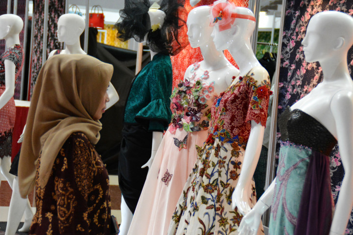 Seorang pengunjung melihat busana batik pada Pameran Semarang Industri Fashion.