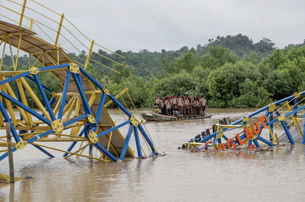 Sejumlah siswa melintas di lokasi jembatan apung yang patah di Desa Ujung Alang, Kampung Laut, Cilacap, Jateng, Jumat (2/12/2016).