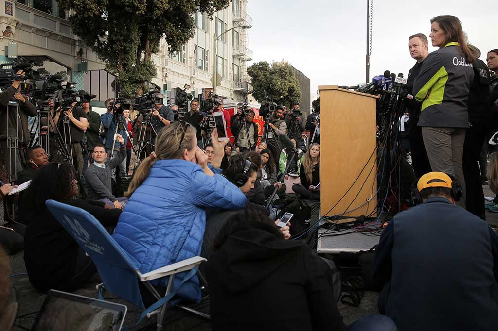 Sersan Ray Kelly dari Departemen Kepolisian Oakland dan Wali Kota Oakland Libby Schaaf menjawab pertanyaan wartawan terkait kebakaran yang menewaskan puluhan orang. Hingga kini petugas masih menyelidiki penyebab kebakaran tersebut.