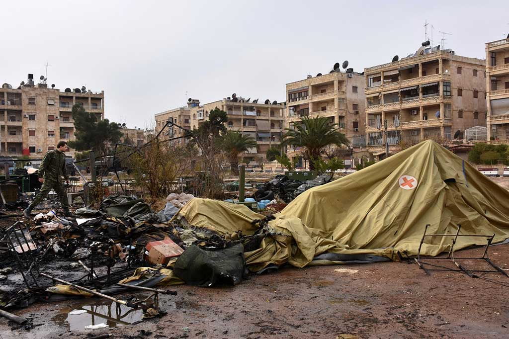 Seorang tentara Rusia memeriksa kerusakan di sebuah rumah sakit lapangan yang hancur diserang pemberontak di lingkungan Furqan, Aleppo barat, Senin.