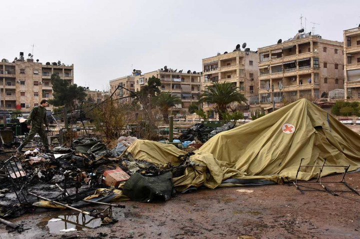 Seorang tentara Rusia memeriksa kerusakan di sebuah rumah sakit lapangan yang hancur diserang pemberontak di lingkungan Furqan, Aleppo barat, Senin.