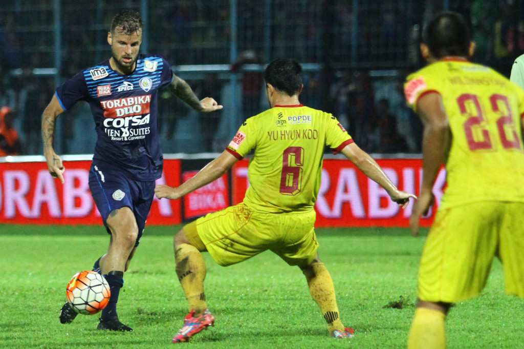 Pesepakbola Arema Cronus, Nick Kalmar (kiri) berusaha melewati hadangan pesepakbola Sriwijaya FC, Yu Hyun Koo.