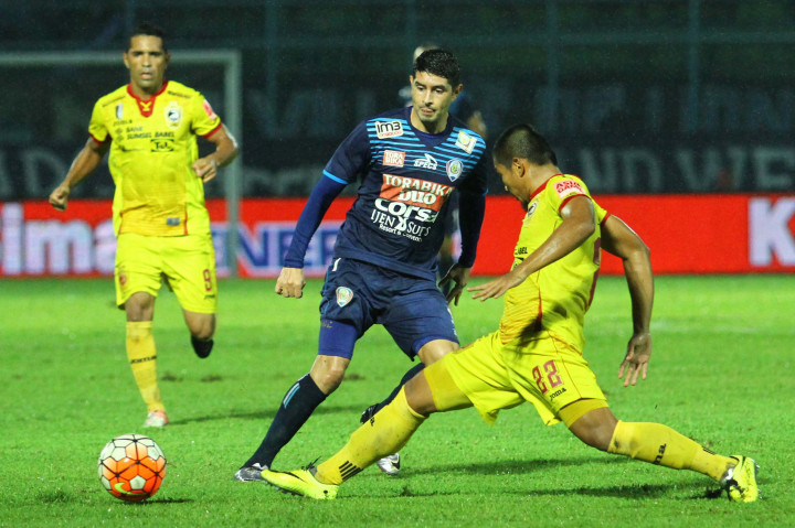 Pesepakbola Arema Cronus, Esteban Viscarra (tengah), berusaha melewati hadangan pesepakbola Sriwijaya FC, Wildansyah (kanan).