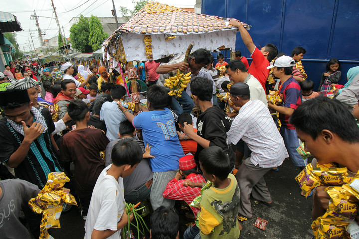 Warga berebut gunungan saat pawai Maulid Nabi, di kawasan Rangkah, Surabaya, Jawa Timur.