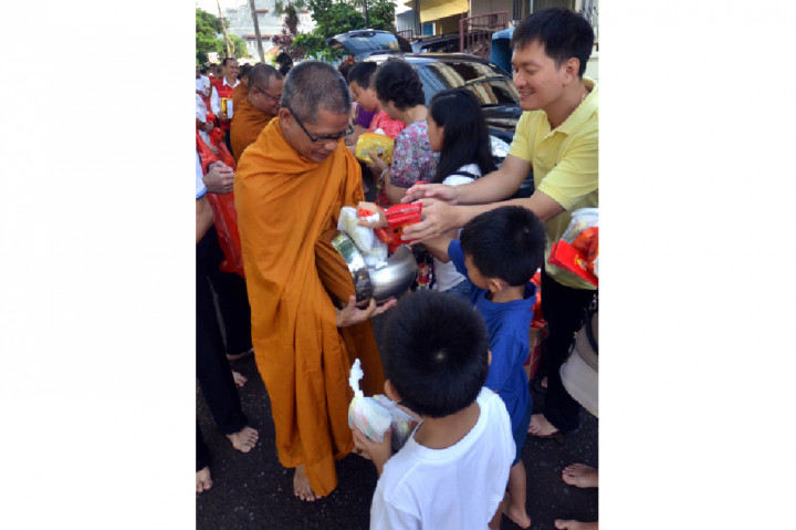 Umat Budha memberikan derma kepada Biksu yang menggelar ritual Pindapatta.