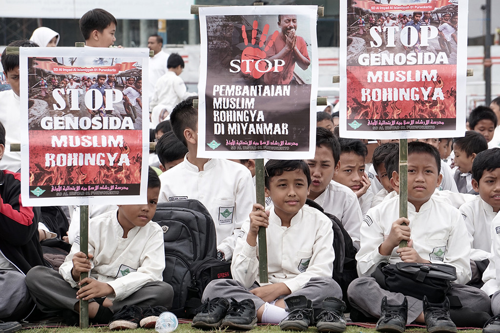 Sejumlah siswa membawa poster yang mengutuk tagedi Rohingya saat melakukan penggalangan dana bagi Muslim Rohingya dan korban gempa Aceh di Alun-alun Purwokerto.