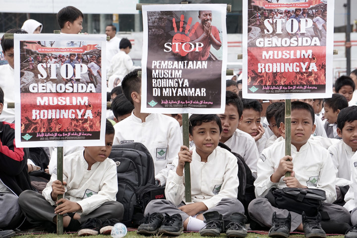 Sejumlah siswa membawa poster yang mengutuk tagedi Rohingya saat melakukan penggalangan dana bagi Muslim Rohingya dan korban gempa Aceh di Alun-alun Purwokerto.