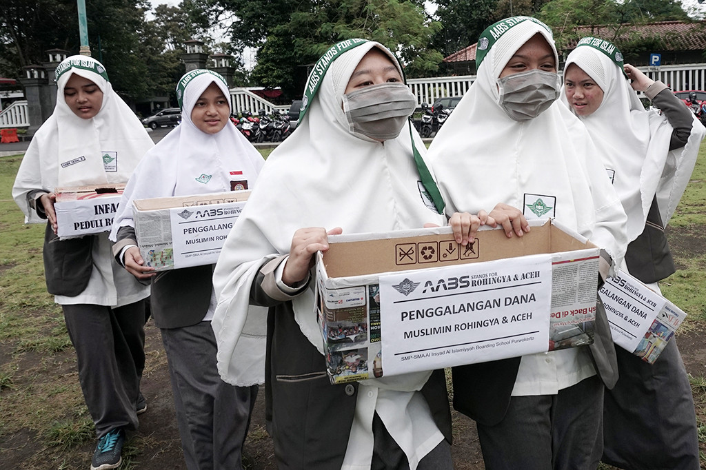 Sejumlah siswa membawa kotak sumbangan saat melakukan penggalangan dana bagi Muslim Rohingya dan korban gempa Aceh, di Alun-alun Purwokerto.