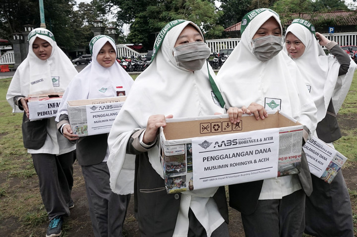 Sejumlah siswa membawa kotak sumbangan saat melakukan penggalangan dana bagi Muslim Rohingya dan korban gempa Aceh, di Alun-alun Purwokerto.