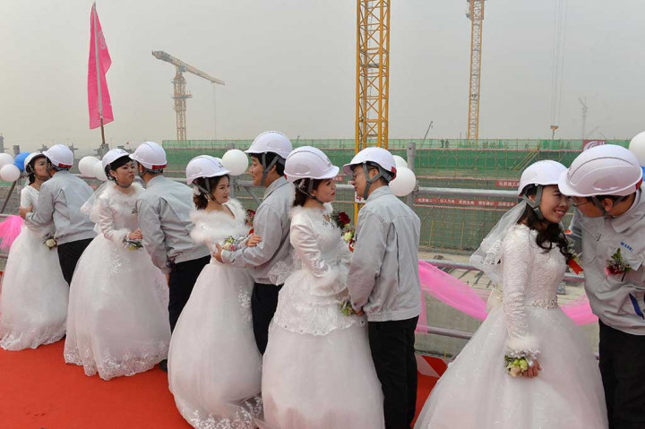 Raut muka gembira terpancar dari lima pekerja konstruksi bersama istri masing-masing usai melangsungkan prosesi pernikahan di lokasi pembangunan bandara di Beijing, Selasa.