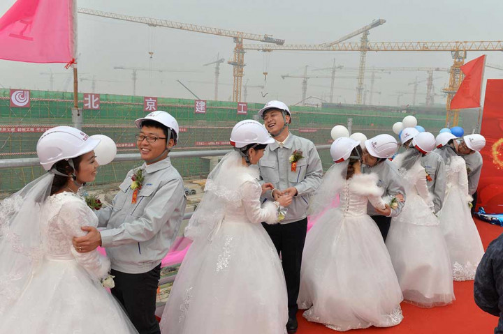 Raut muka gembira terpancar dari lima pekerja konstruksi bersama istri masing-masing usai melangsungkan prosesi pernikahan di lokasi pembangunan bandara di Beijing, Selasa.