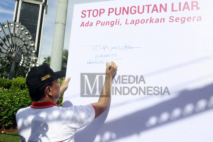 Menkopolhukam Wiranto menandatangani ikrar stop pungutan liar (Pungli) saat membuka kampanye budaya anti pungutan liar di area Car Free Day (CFD).