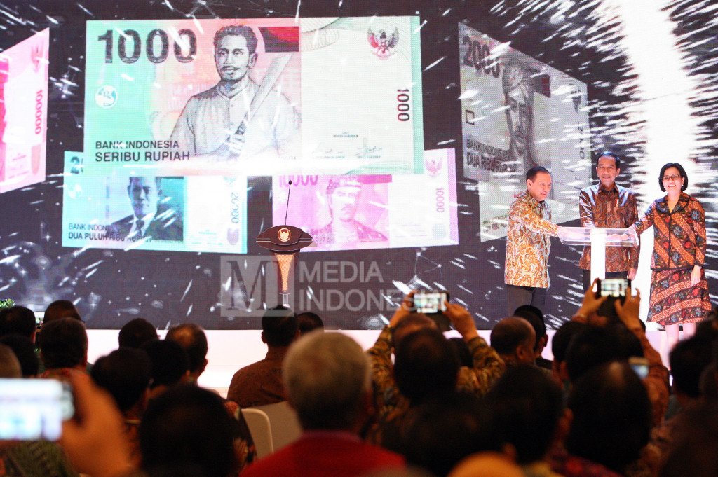 Presiden RI Joko Widodo (tengah) bersama Menteri Keuangan Sri Mulyani Indrawati (kanan) dan Gubernur Bank Indonesia Agus Marto Wardojo meresmikan peluncuran mata uang Rupiah baru di Bank Indonesia, Jakarta.
