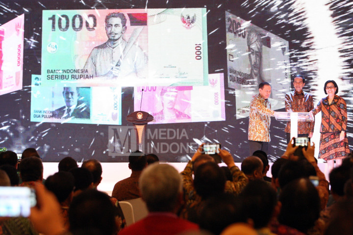 Presiden RI Joko Widodo (tengah) bersama Menteri Keuangan Sri Mulyani Indrawati (kanan) dan Gubernur Bank Indonesia Agus Marto Wardojo meresmikan peluncuran mata uang Rupiah baru di Bank Indonesia, Jakarta.