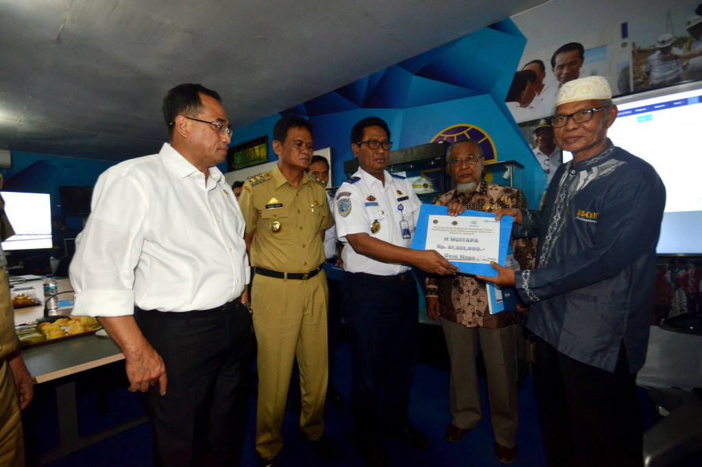 Menteri Perhubungan Budi Karya Sumadi (kiri) menyaksikan penyerahan dana pembebasan lahan rel kereta saat meninjau progres pembangunan proyek rel kereta api trans Sulawesi.