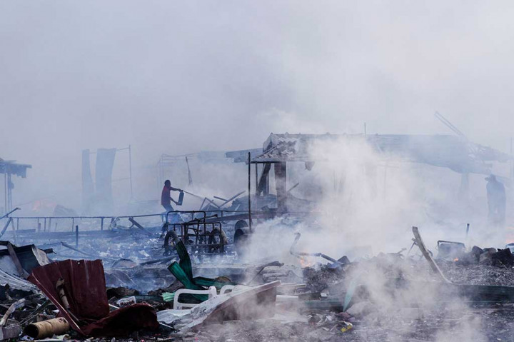 Seorang pria berjuang sendirian saat berusaha memadamkan api di atas reruntuhan pasar kembang api yang meledak dan terbakar di Tultepec, pinggiran Mexico City, Selasa.
