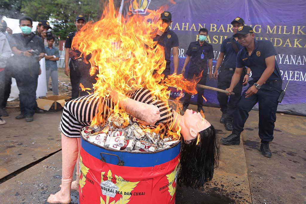 Petugas memusnahkan barang bukti boneka seks dan rokok ilegal.