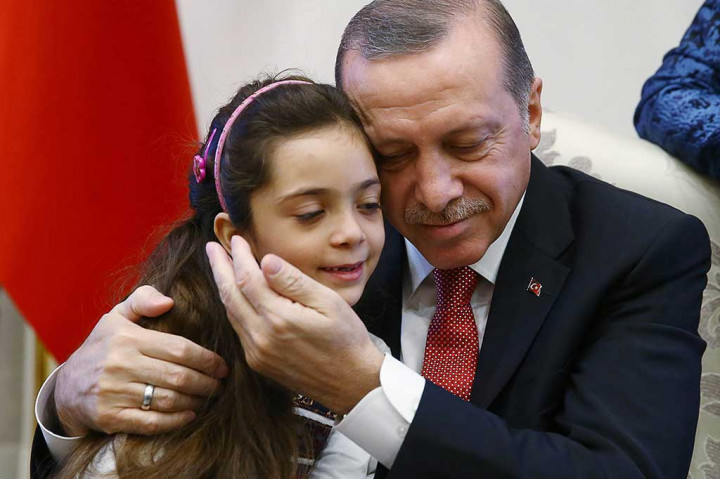 Presiden Turki Recep Tayyip Erdogan memeluk Bana al-Abed saat menerima gadis tersebut beserta keluarganya di Istana Presiden, Ankara, Rabu.