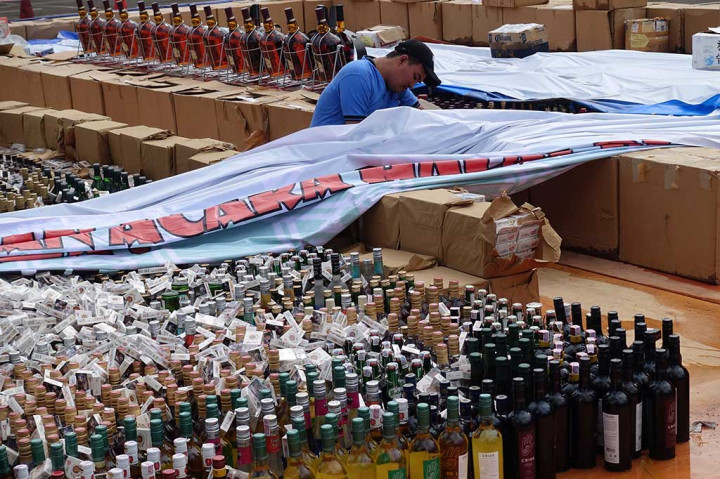 Petugas menutup ribuan rokok dan minuman keras tanpa label cukai yang akan dimusnahkan di halaman Kantor Pusat Ditjen Bea dan Cukai, Jakarta, Kamis (22/12/2016).