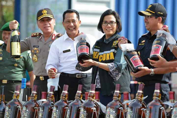 Menteri Keuangan Sri Mulyani (kedua kanan) bersama Kepala BNN Komjen Budi Waseso (kedua kiri), Dirjen Pajak Heru Pambudi (kanan), dan Kapolda Metro Jaya Irjen Pol M. Iriawan menunjukkan botol minuman keras tanpa pita cukai sebelum pemusnahan di halaman kantor pusat DJBC, Jakarta, Jumat (23/12/2016).