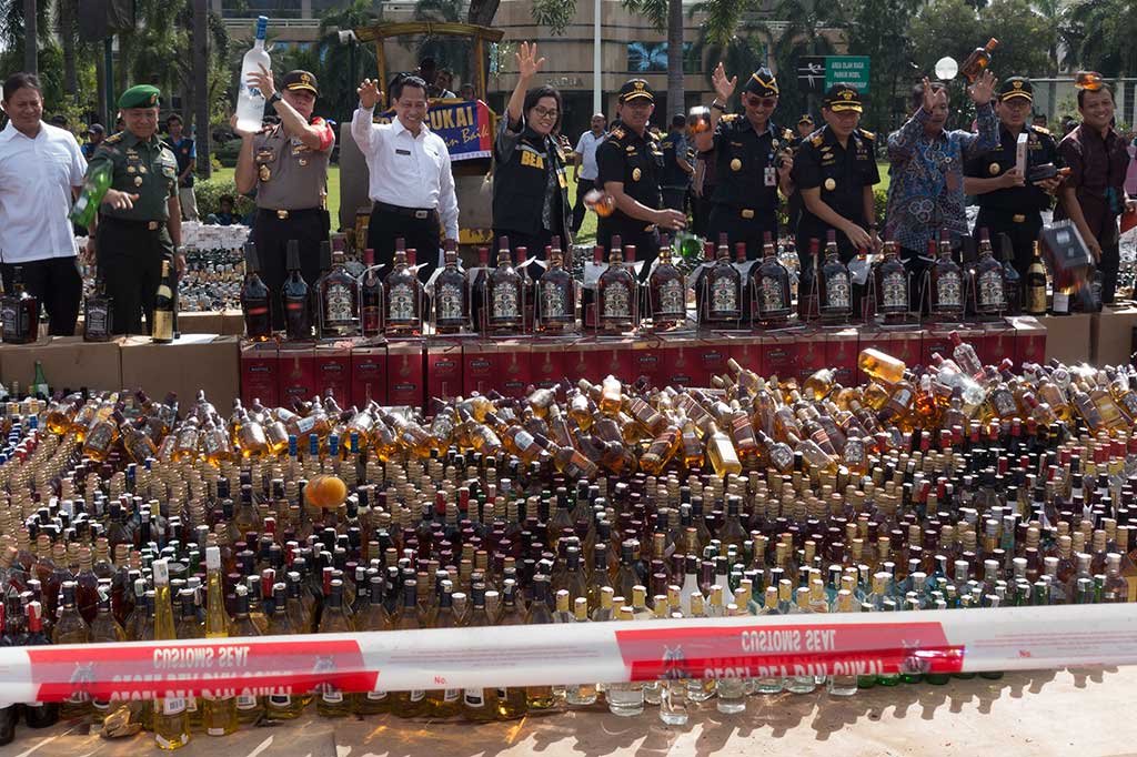 Menkeu Sri Mulyani bersama Kepala BNN Komjen Budi Waseso (keempat kiri), Dirjen Pajak Heru Pambudi (keenam kiri), dan Kapolda Metro Jaya Irjen Pol M. Iriawan, serta pejabat lainnya melempar botol minuman keras tanpa pita cukai sebelum pemusnahan di halaman kantor pusat DJBC, Jakarta.