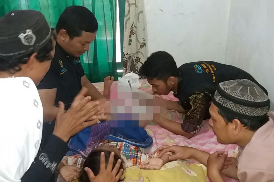 Dokter sedang melakukan tindakan medis pada peserta sunatan massal.