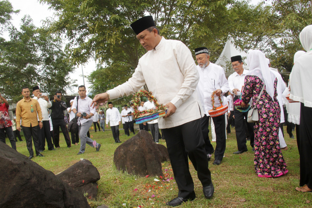 Plt Gubernur Aceh, Soedarmo (kiri) bersama Wali Nanggroe Aceh, Malik Mahmud (kedua kanan) dan pejabat muspida Aceh menabur bunga saat ziarah di kuburan massal korban tsunami Aceh di Desa Ulee Lheue, Banda Aceh.