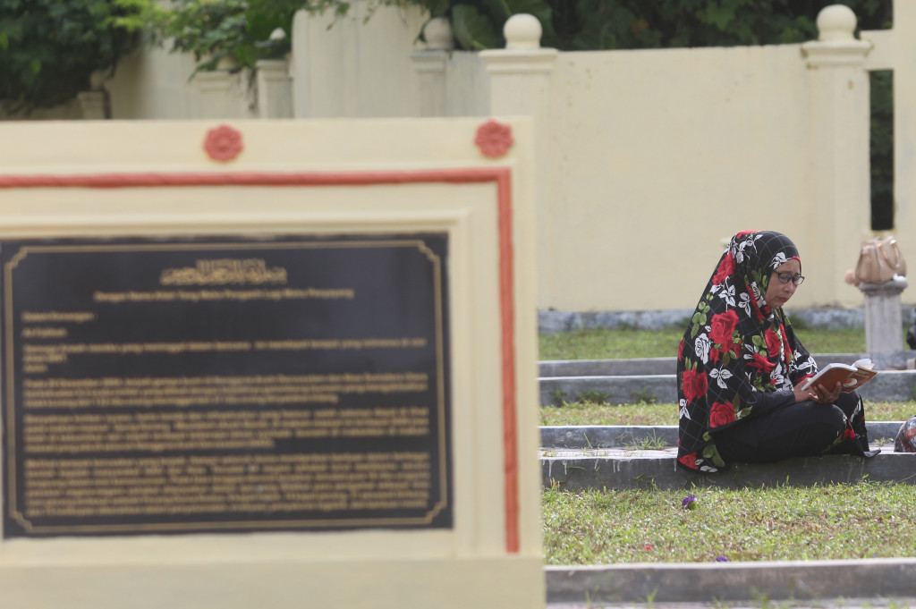 Warga berdoa di kuburan massal Desa Suak Indrapuri, Kecamatan Johan Pahlawan, Aceh Barat, Aceh.