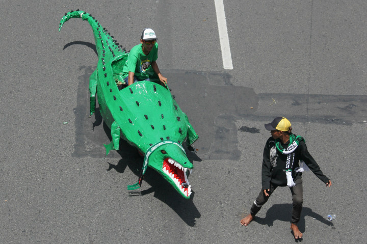 Seorang suporter Persebaya mengendarai replika Buaya saat Parade Bela Persebaya.
