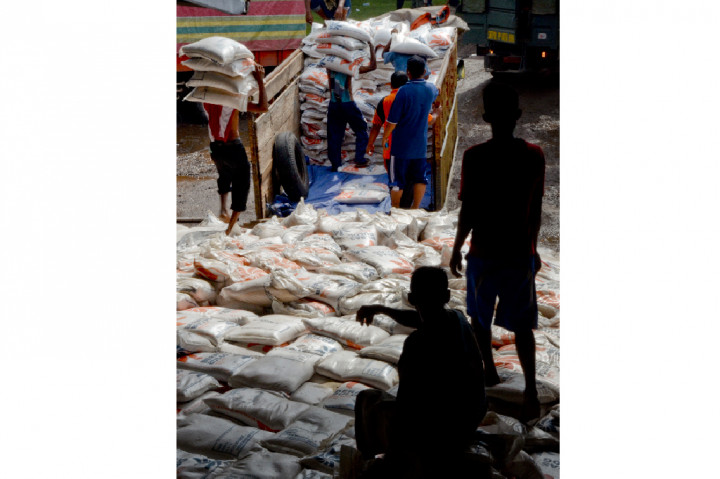 Sejumlah buruh mengangkat sisa beras yang selamat dari banjir di gudang Bulog Kelurahan Jatiwangi, Kota Bima, NTB.