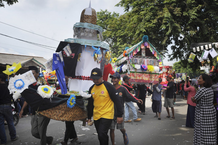 Sejumlah warga menggotong aneka barang sedekah saat acara tradisi Panjang Mulud di Tanggul, Serang, Banten.