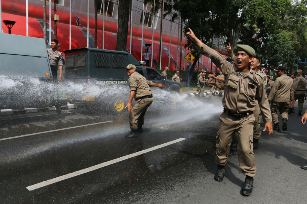 Petugas Satpol PP disemprot menggunakan mobil water canon pada simulasi sistem pengamanan kota di Medan, Sumatera Utara.