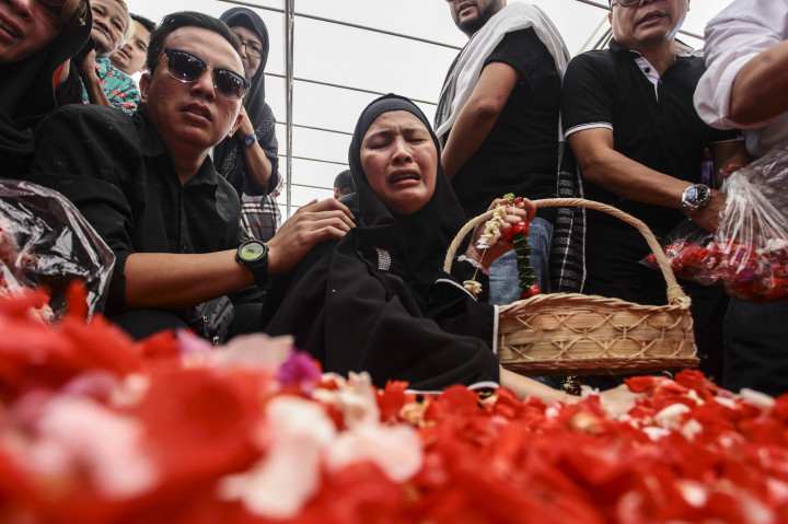 Rosi Herawati, ibunda dari korban penyekapan, Dianita Gemma Dzalfayla dan Diona Arika Andra Putri menaburkan bunga di makam kedua anaknya.