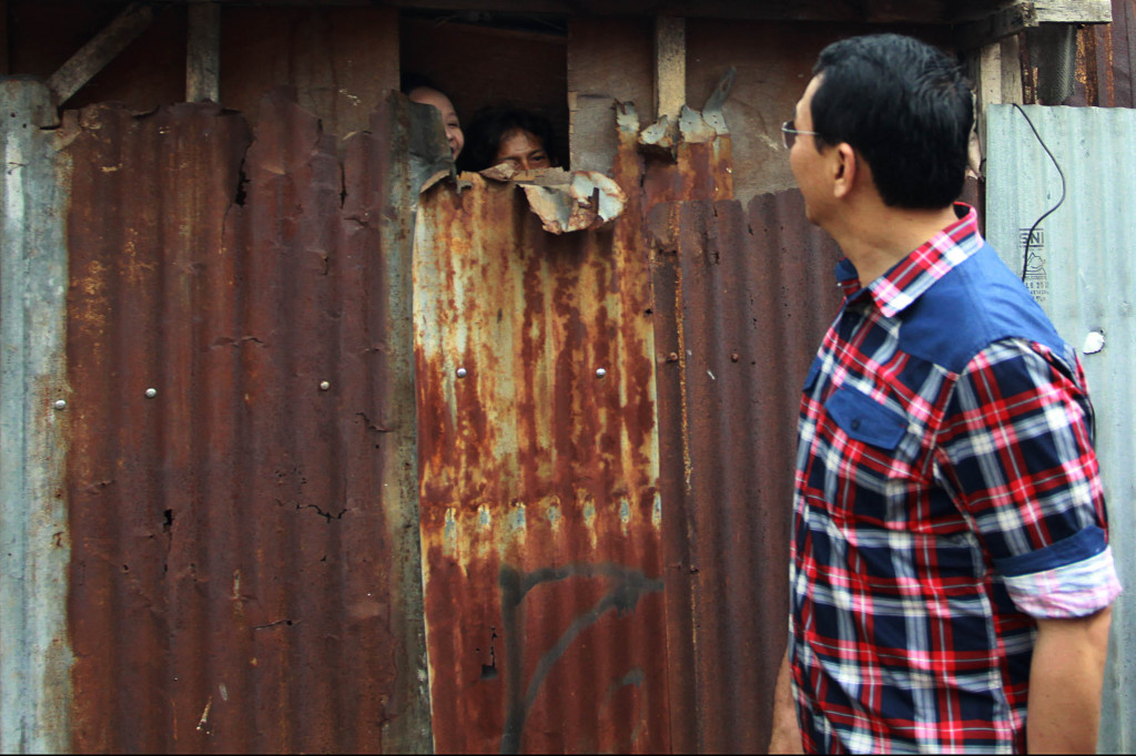 Ahok membalas sapaan warga penyapanya dari cendela kecil rumahnya yang pagar seng di Jl Ketapang, Jati Padang, Pasar Minggu, Jakarta Selatan.