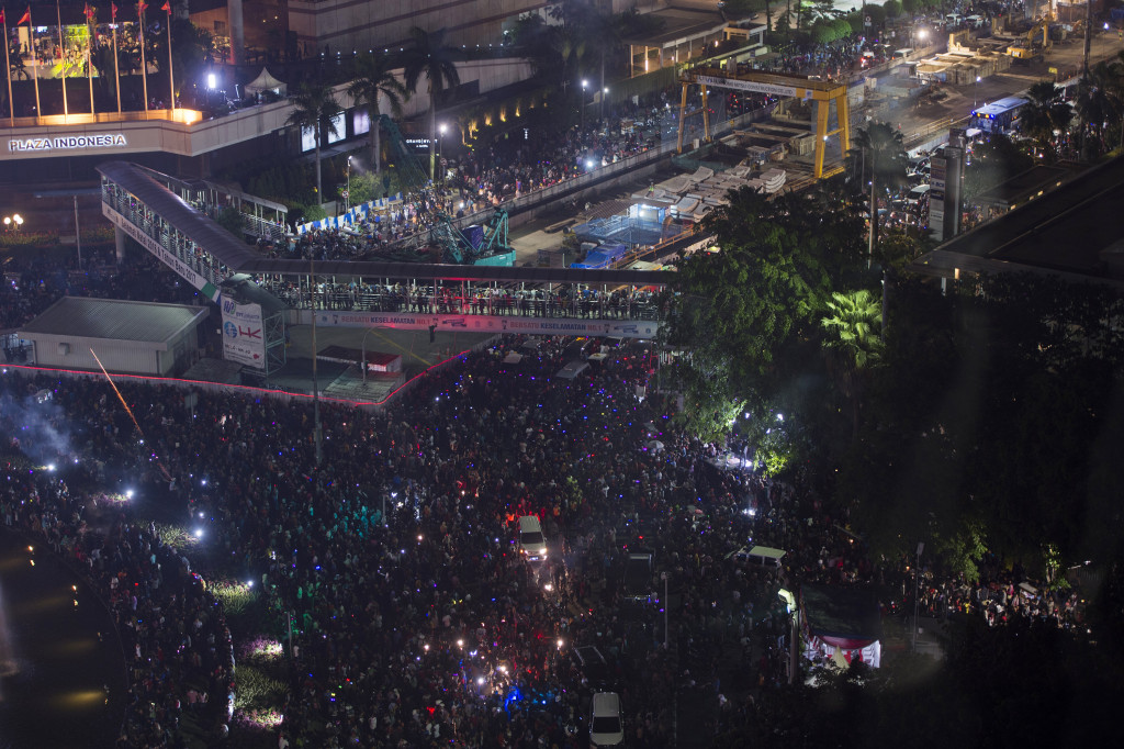 Warga memadati Jalan MH. Thamrin pada malam pergantian tahun di kawasan Bundaran HI, Jakarta.