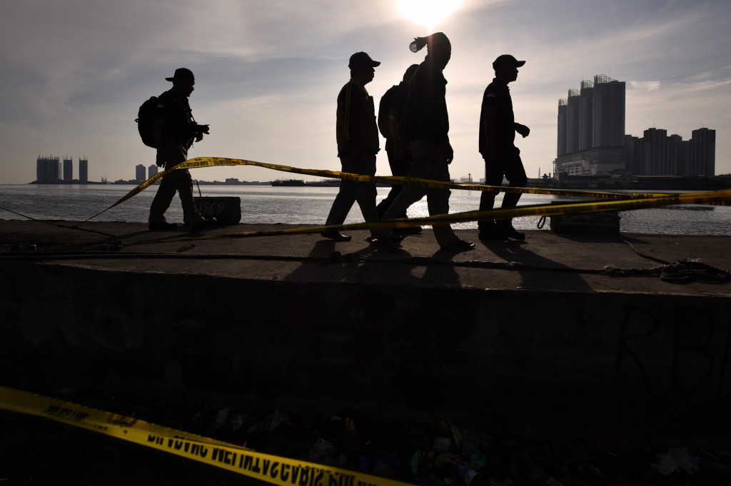 Sejumlah petugas KNKT berjalan di dekat bangkai Kapal Zahro Express yang terbakar saat melakukan investigasi di Pelabuhan Kali Adem, Muara Angke, Jakarta.