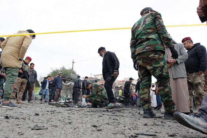 Pasukan keamanan Irak mencari barang bukti di tempat kejadian serangan bom di Kota Sadr.