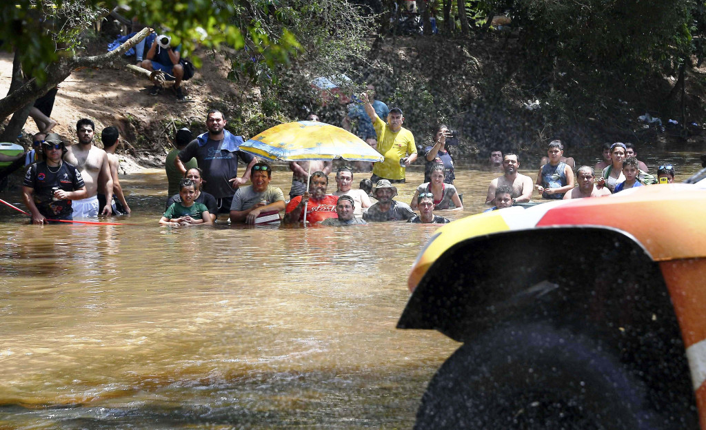 Sebagian jalur etape pertama ini melintasi sungai di tengah hutan lebat. Maka warga sekitar pun menonton dengan menceburkan diri ke dalam sungai. AFP Photo/Franck Fife