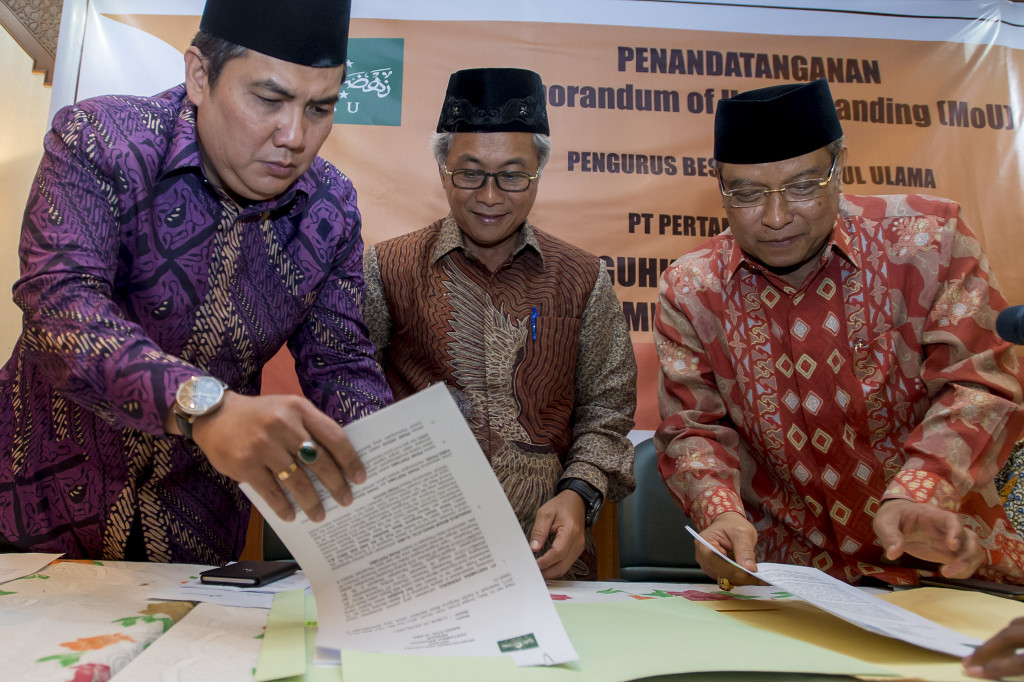 Direktur Utama PT Pertamina (Persero) Dwi Soetjipto (tengah) dan Ketua Umum PB Nahdlatul Ulama (PBNU) K.H. Said Aqil Siroj (kanan) disaksikan Sekjen PBNU Helmy Faishal Zaini menandatangani dokumen Nota Kesepahaman (MoU) di Gedung PBNU, Jakarta.