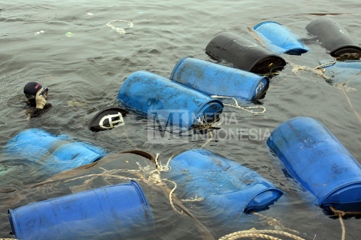 Petugas menggunakan drum untuk mengangkat bangkai kapal Zahro Express di Pelabuhan Muara Angke, Jakarta