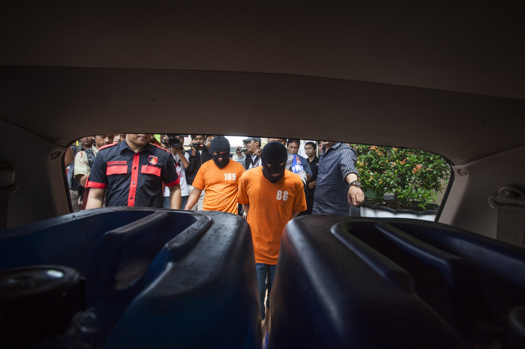 Petugas kepolisian menunjukan tersangka dan barang bukti miras sitaan saat gelar kasus miras di Polres Sleman, DI Yogyakarta, Rabu (4/1/2017).