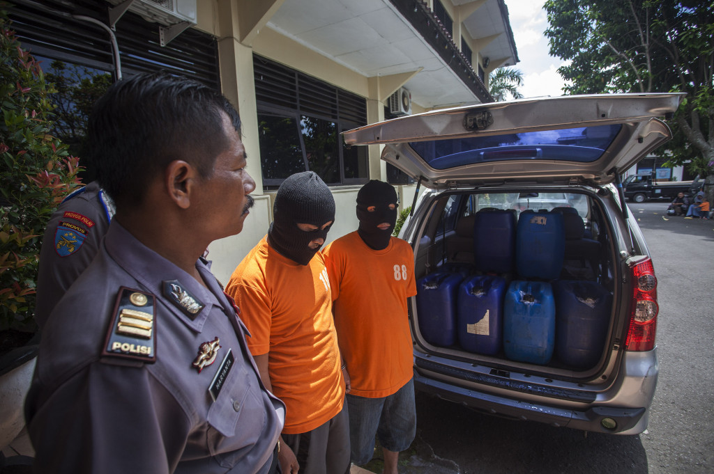 Petugas kepolisian menunjukan tersangka dan barang bukti miras sitaan saat gelar kasus miras di Polres Sleman, DI Yogyakarta, Rabu (4/1/2017).