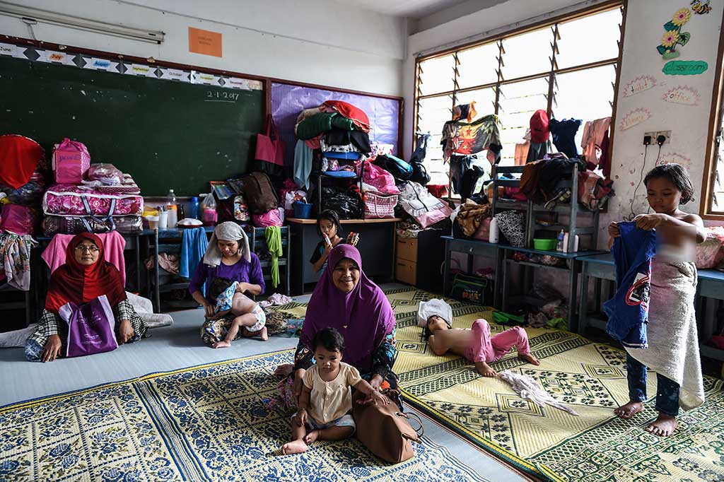Warga korban banjir mengungsi di sebuah gedung sekolah di Rantau Panjang, Kelantan.