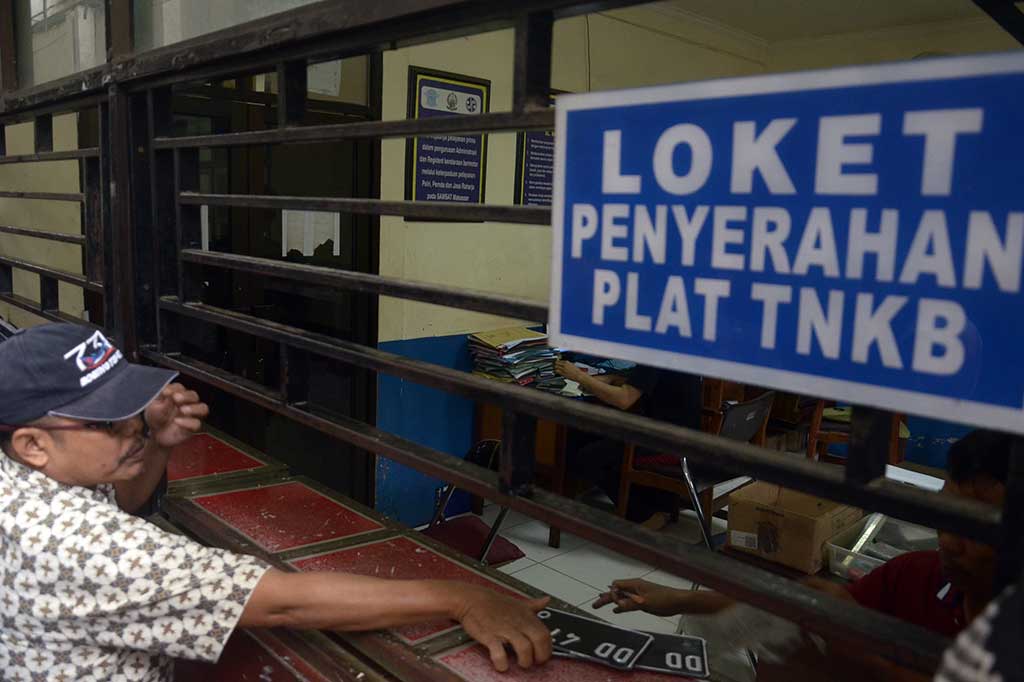 Pemilik kendaraan mengambil plat nomor polisi di loket penyerahan Plat TNBK kantor Samsat Kota Makassar, Sulawesi Selatan. ANTARA/Darwin Fatir