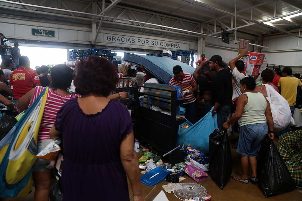 Para penjarah memakai kantong-kantong besar untuk membawa barang jarahan.