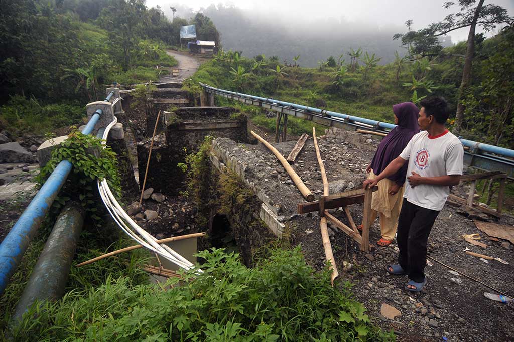 Warga menyaksikan jembatan yang ambruk di Desa Cawitali, Bumijawa, Tegal, Jateng, Jumat (6/1/2017). 